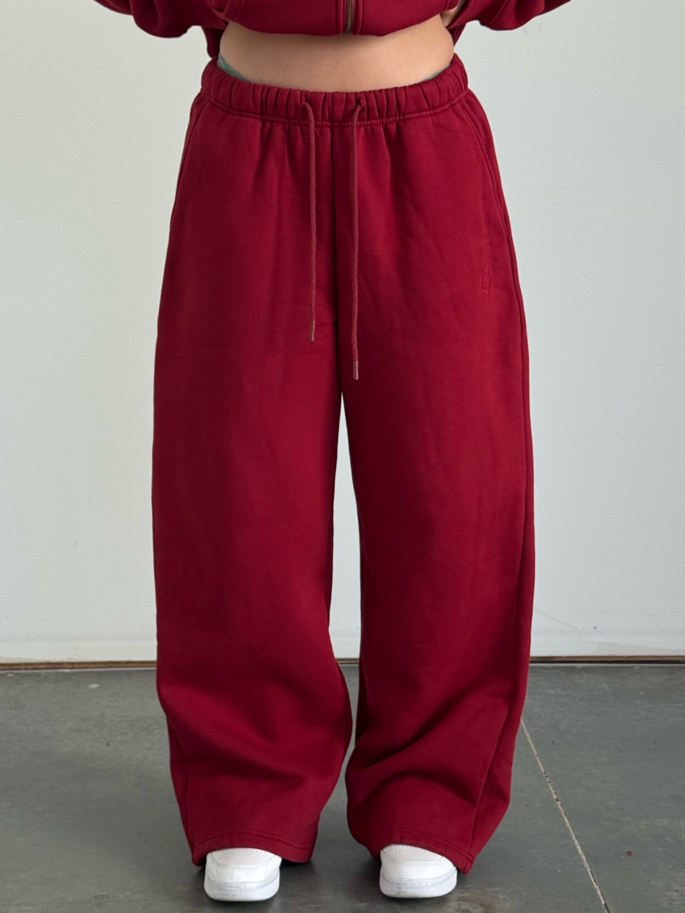 Person wearing a red tracksuit against a plain background
