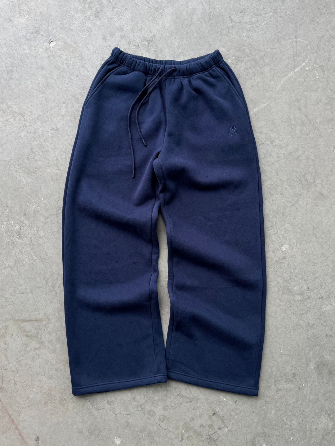 Navy blue pants on a gray concrete floor