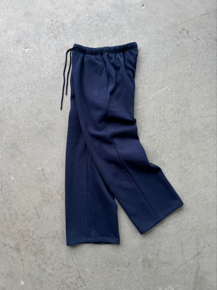 Navy blue pants on a gray concrete surface