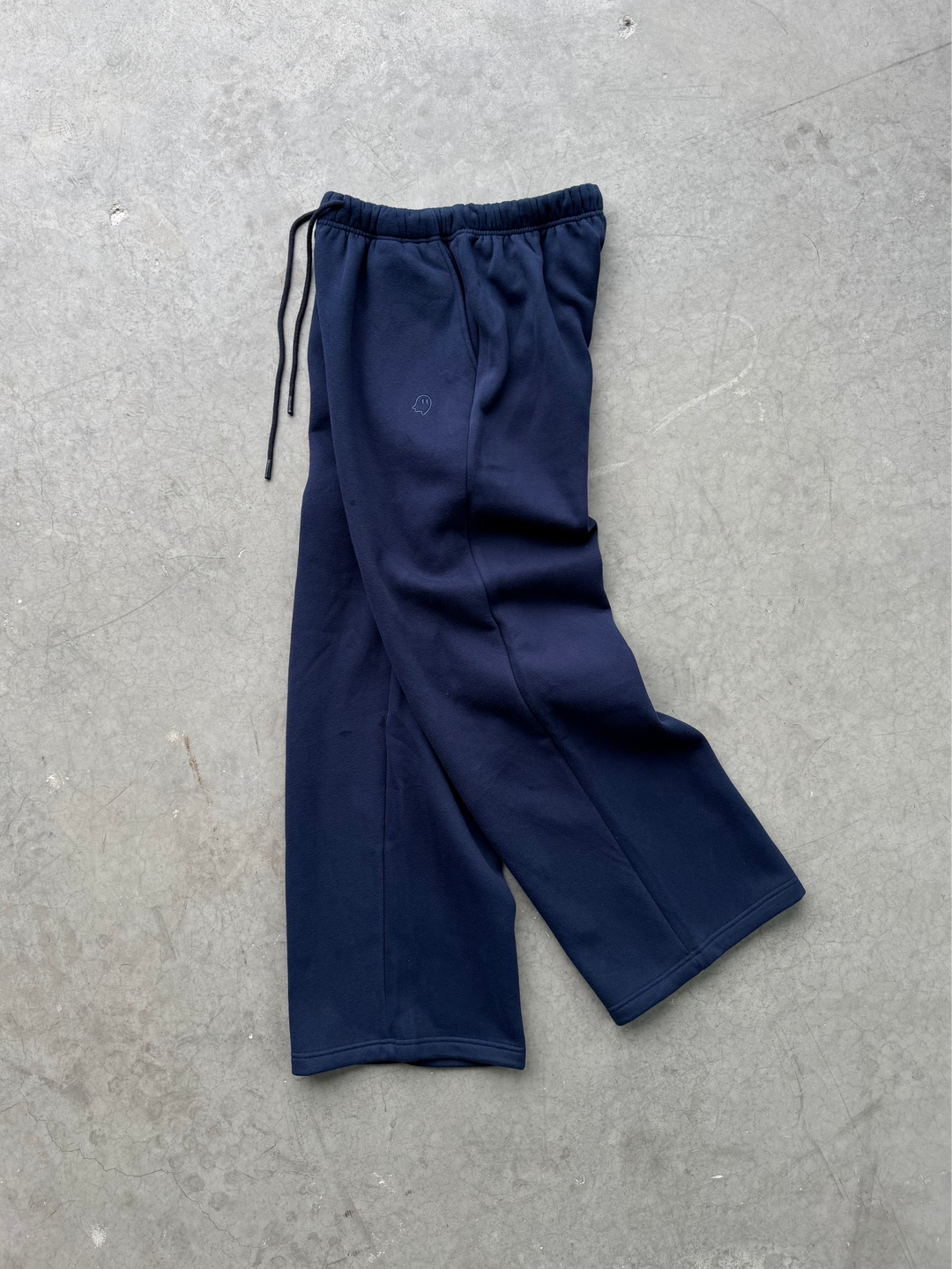 Navy blue pants on a gray concrete surface