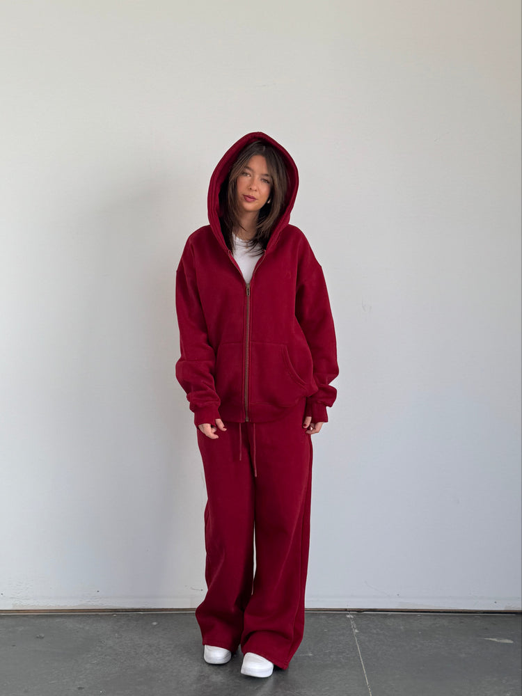 Person wearing a red onesie against a plain background