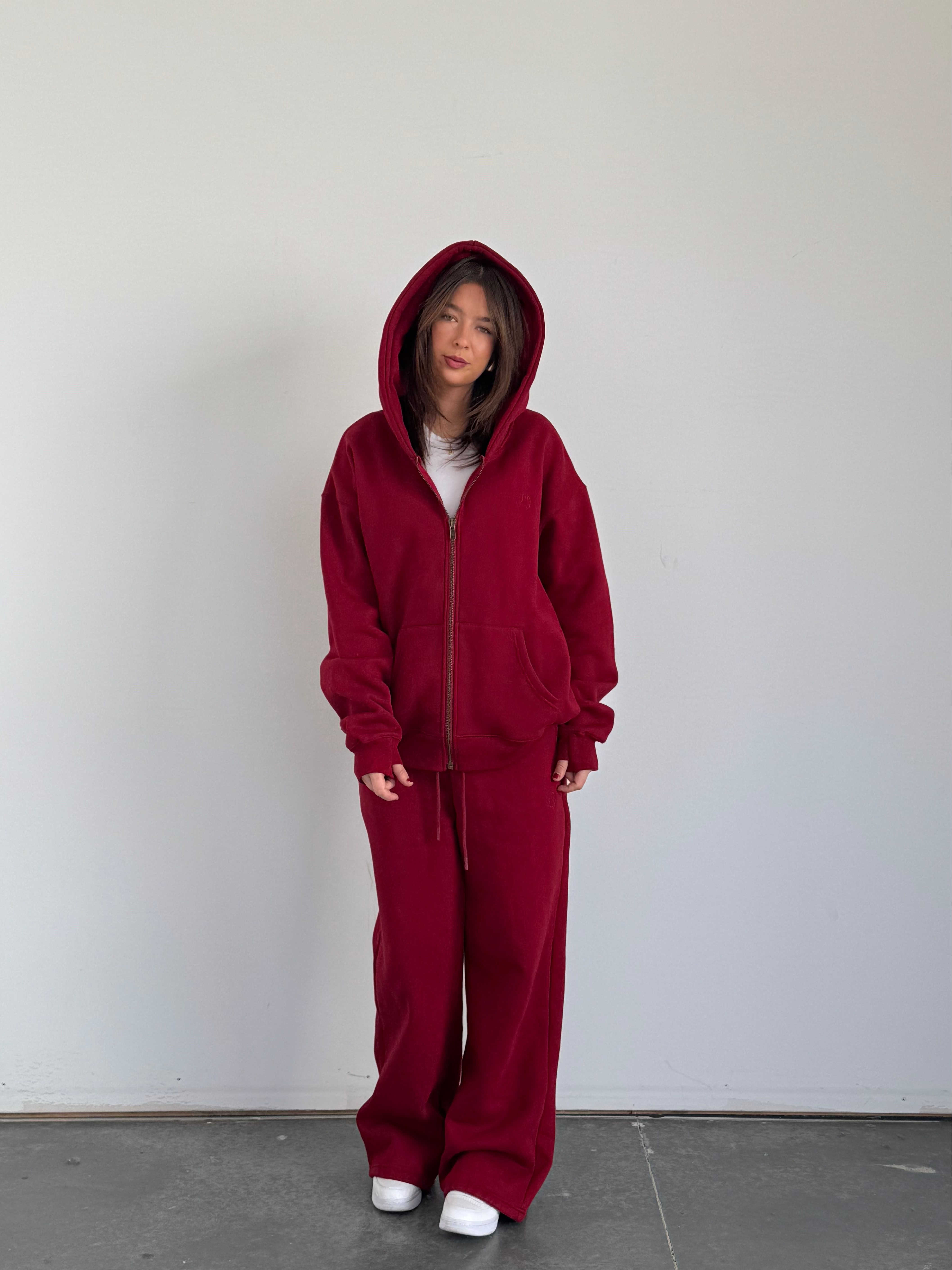 Person wearing a red onesie against a plain background