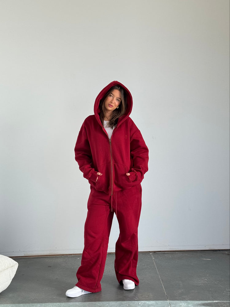 Person wearing a red onesie against a plain background