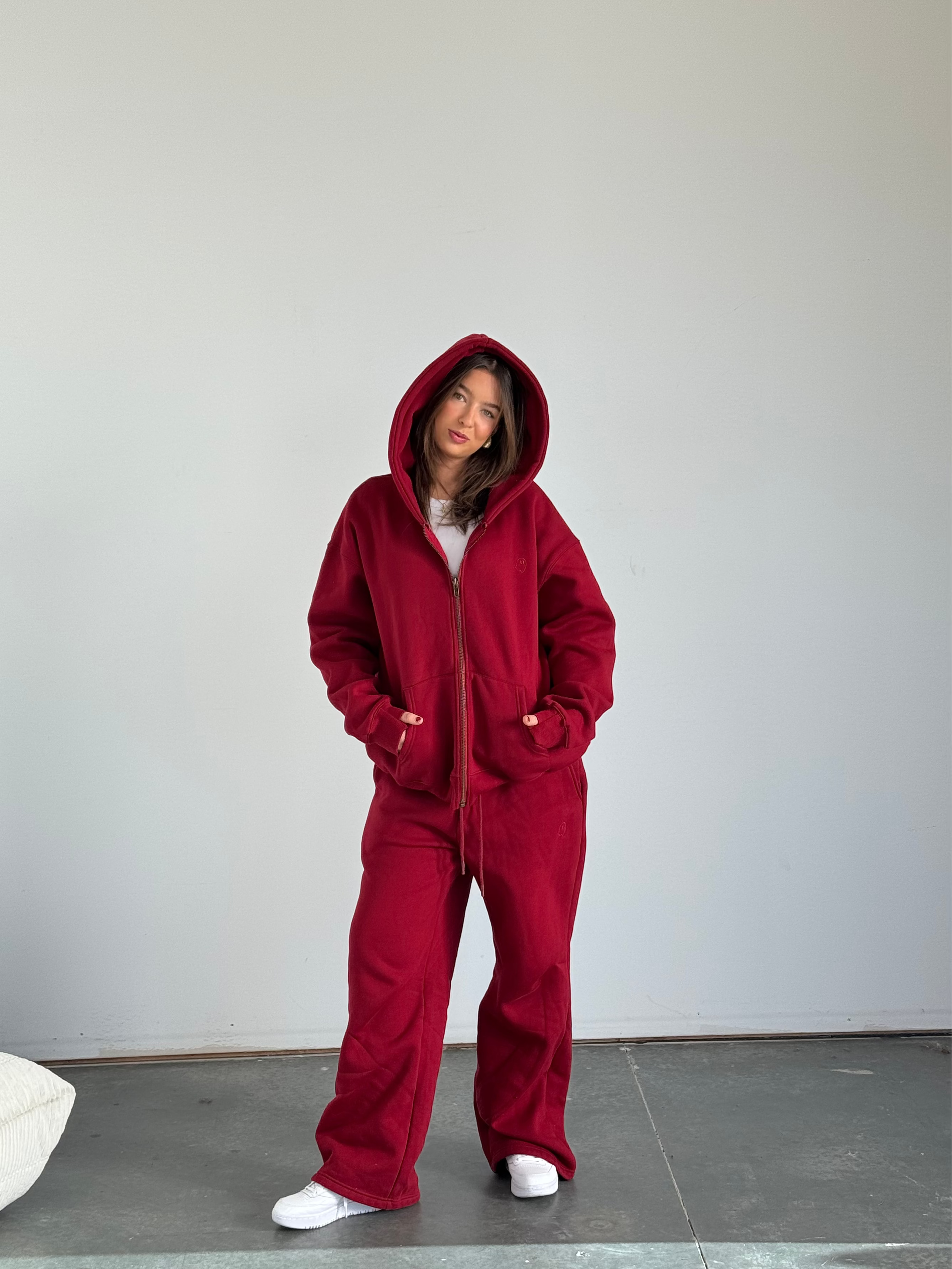Person wearing a red onesie against a plain background