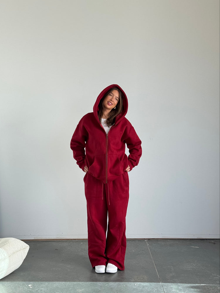 Person wearing a red onesie standing against a plain background
