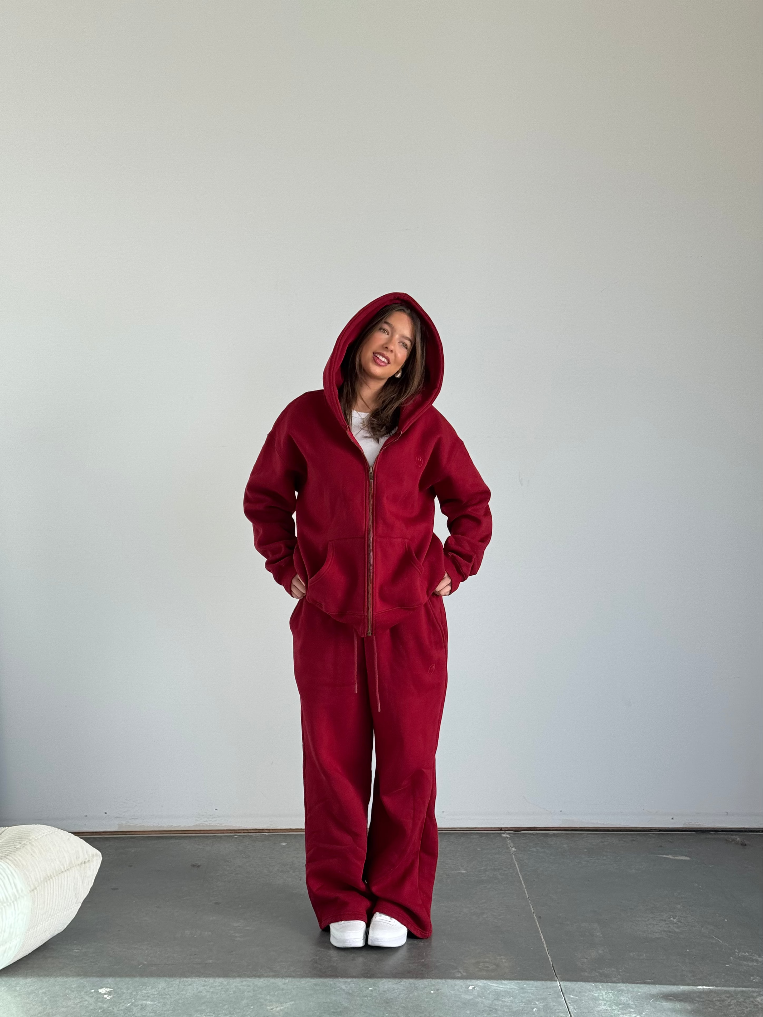 Person wearing a red onesie standing against a plain background