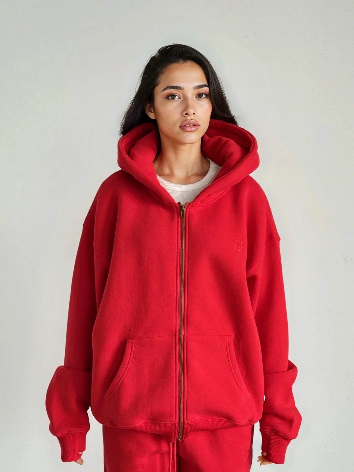 Person wearing a red hoodie and pants on a plain background