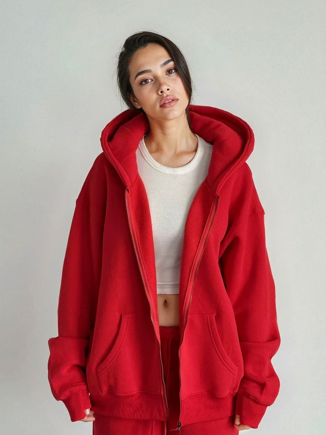 Person wearing a red hoodie and pants on a plain background