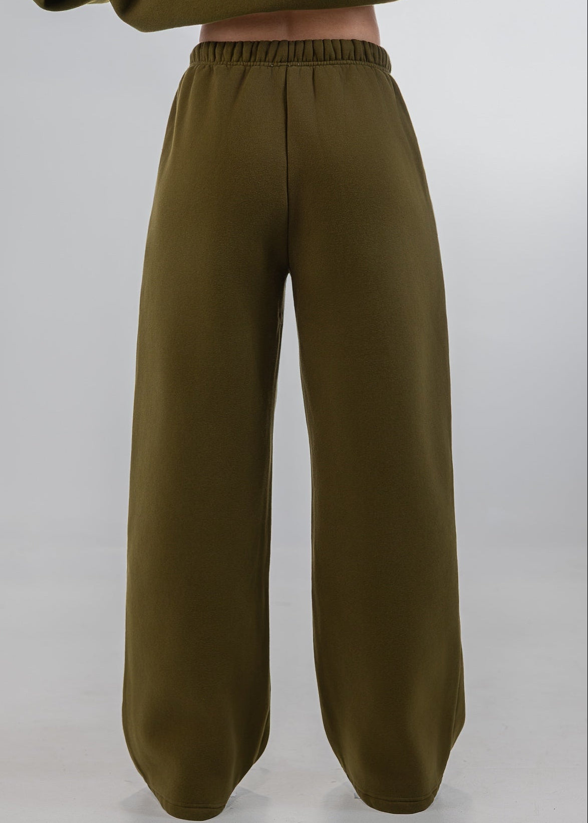 Olive green wide-leg sweatpants with an elastic waistband, shown on a model from the back against a light gray studio background.