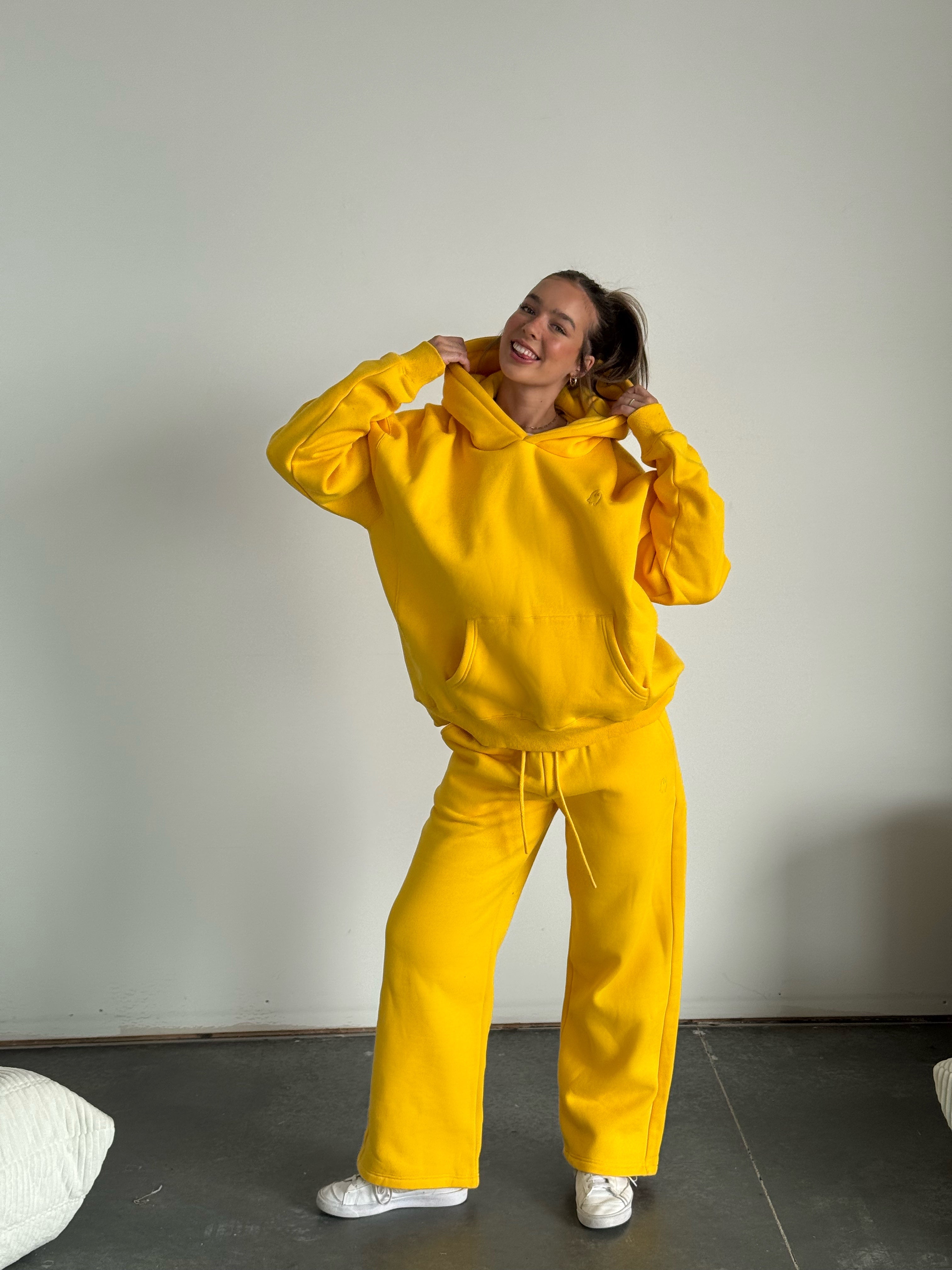 Person wearing a bright yellow tracksuit against a plain background