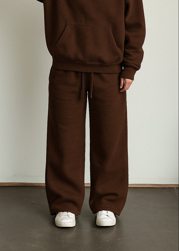 Person wearing a brown hoodie and pants set against a plain background