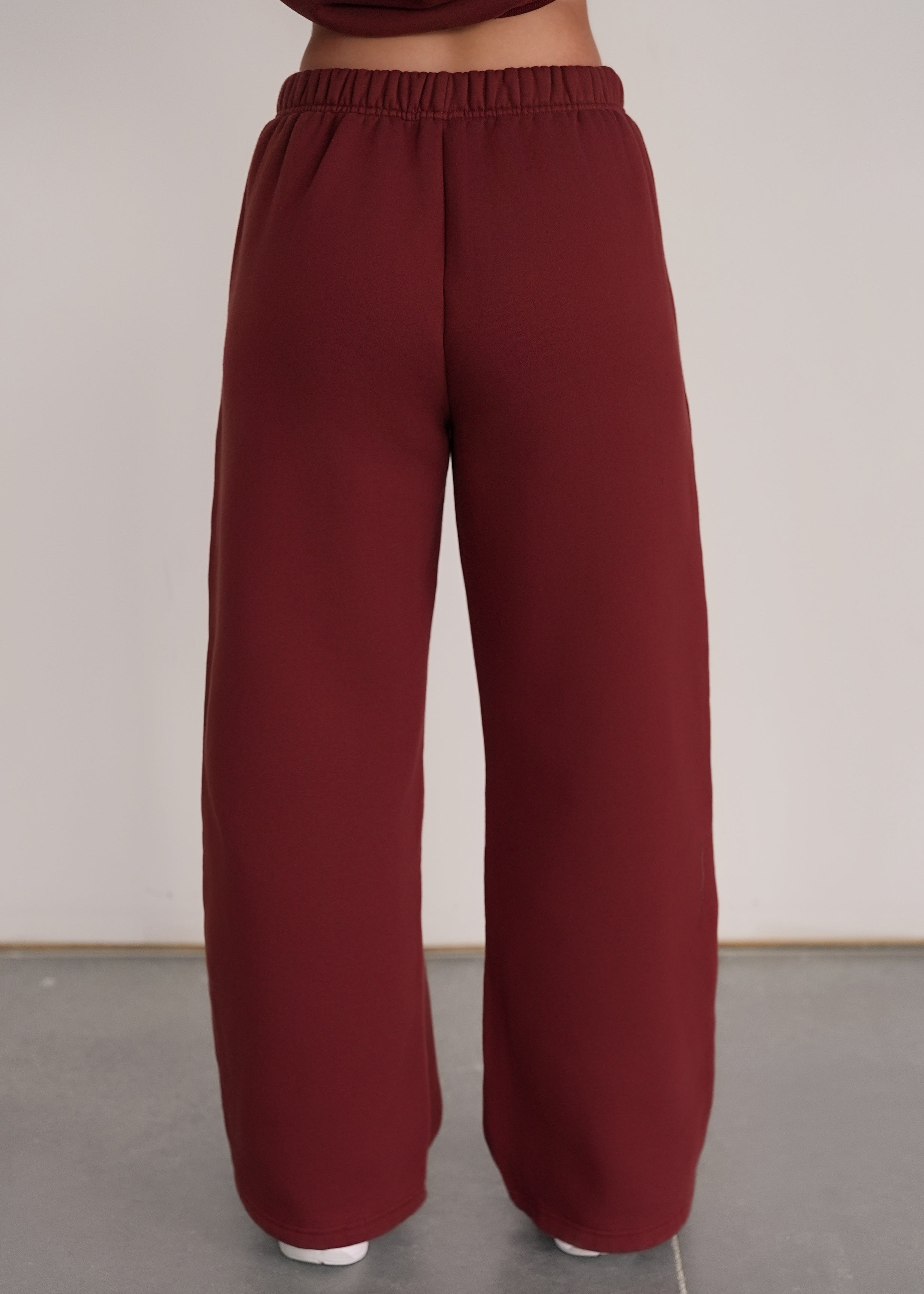 Maroon wide-leg pants worn by a person on a plain background