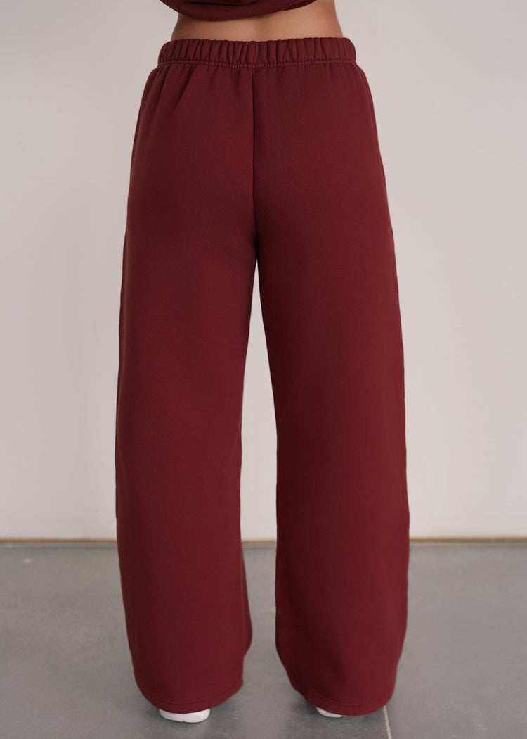 Maroon wide-leg pants worn by a person on a plain background