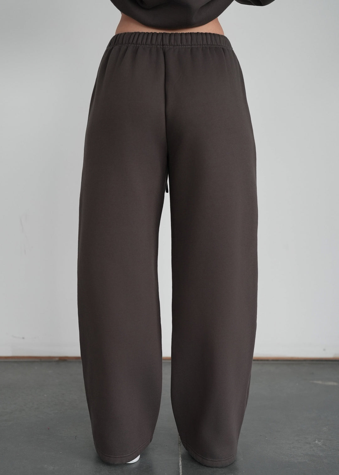 Person wearing brown wide-leg pants against a plain background