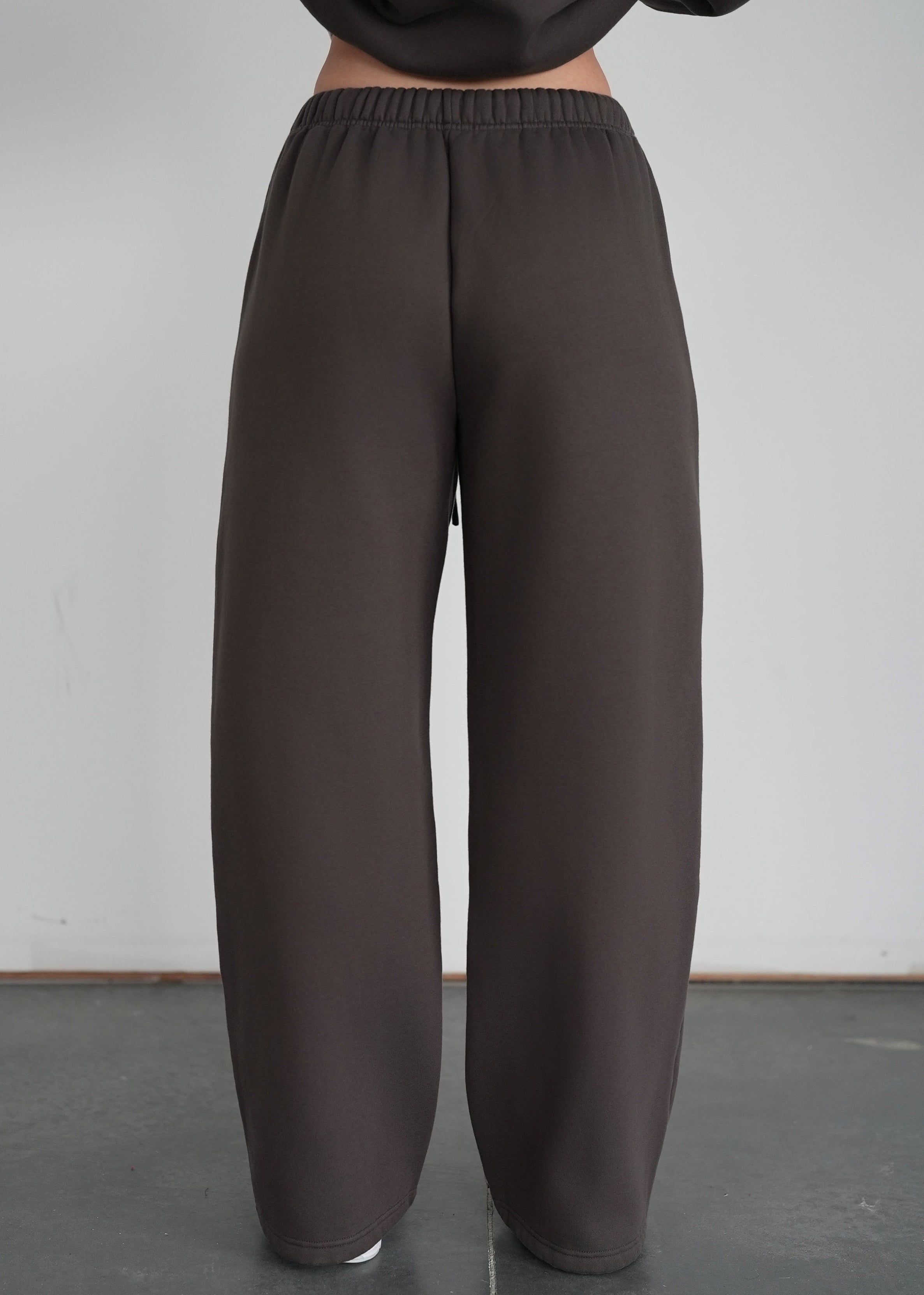 Person wearing brown wide-leg pants against a plain background