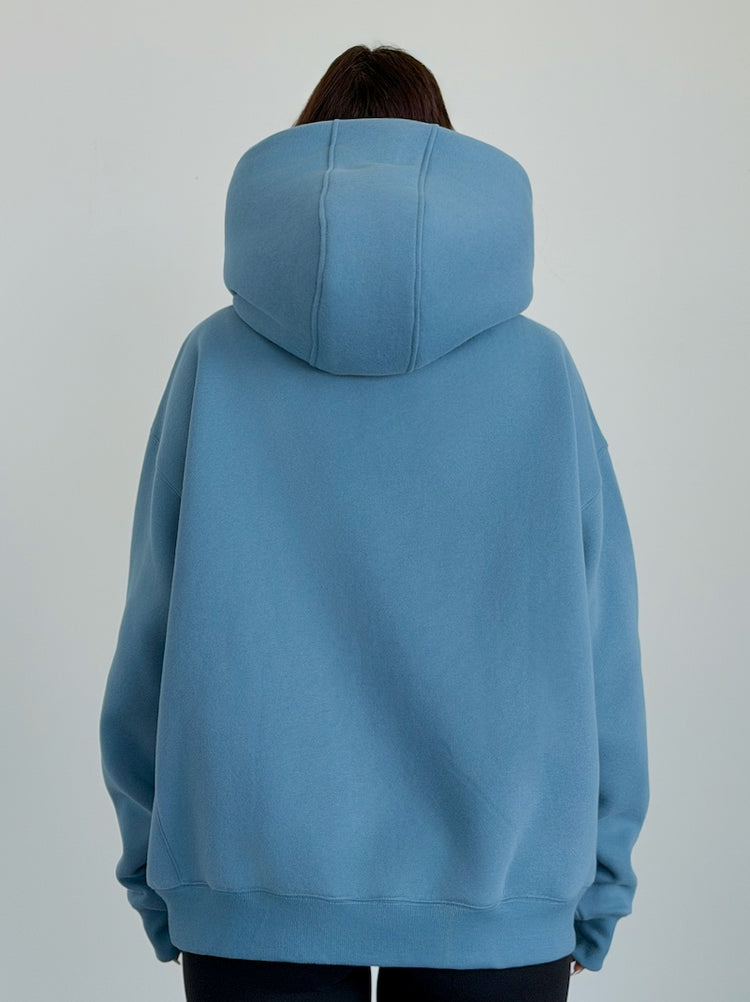 Person wearing a blue hoodie from behind on a plain background