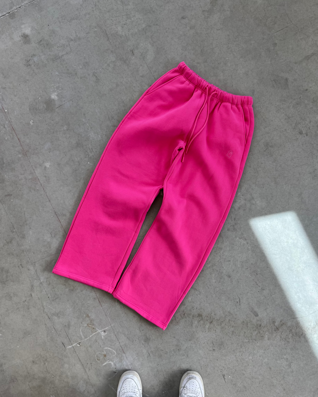 Pink pants on a gray concrete floor