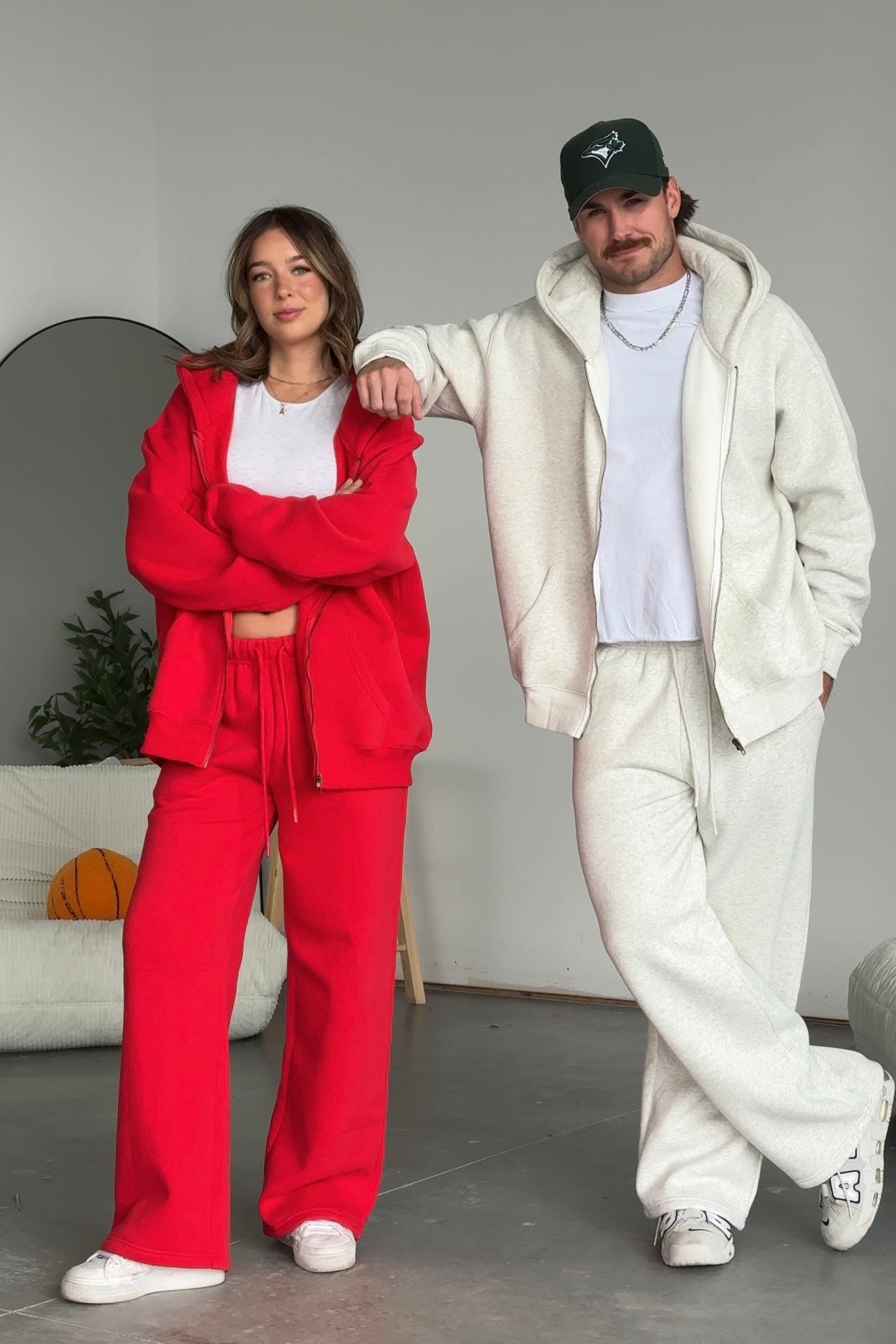 Two people wearing red and white outfits standing indoors.