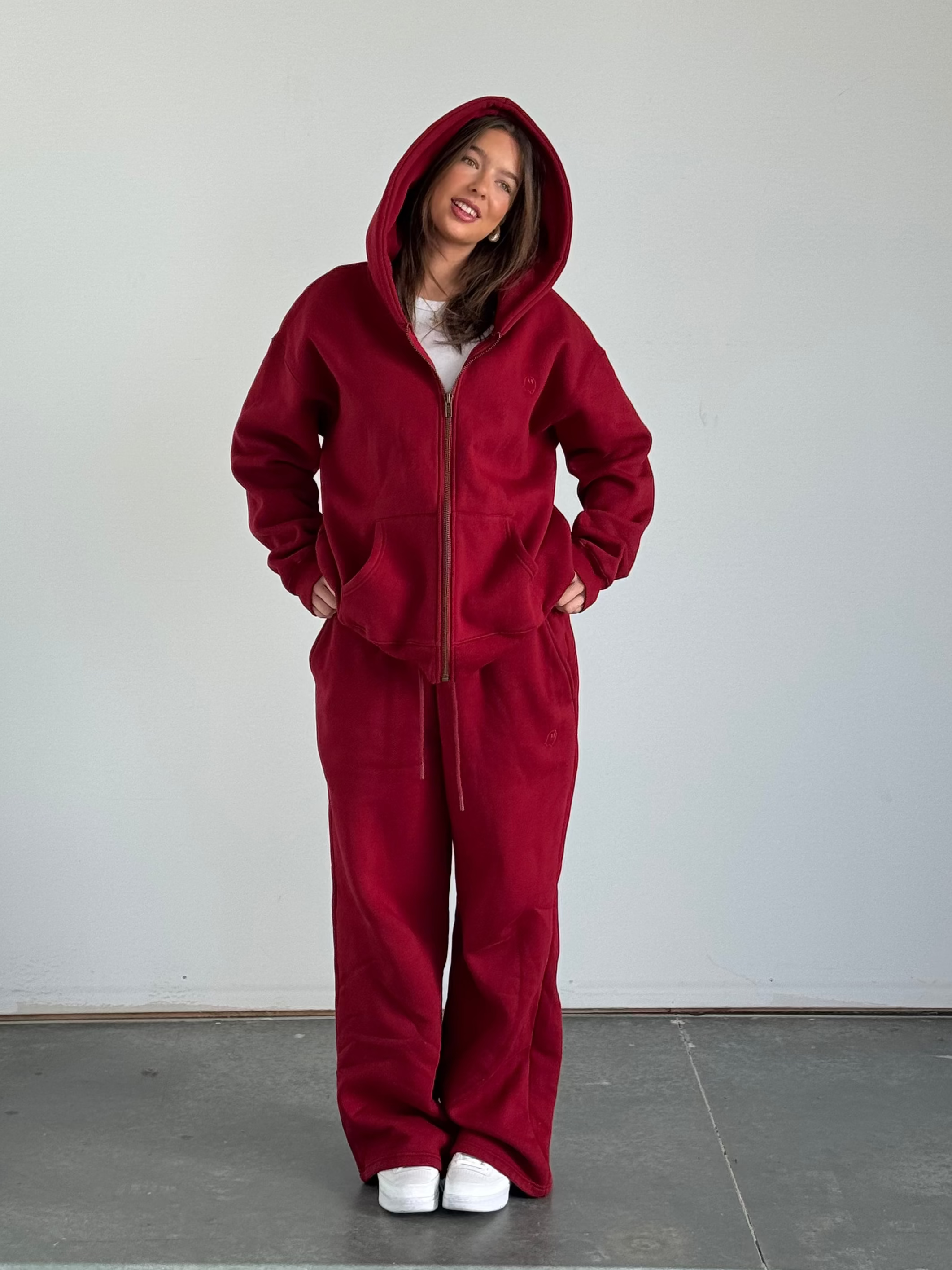 Person wearing a red onesie standing against a plain background