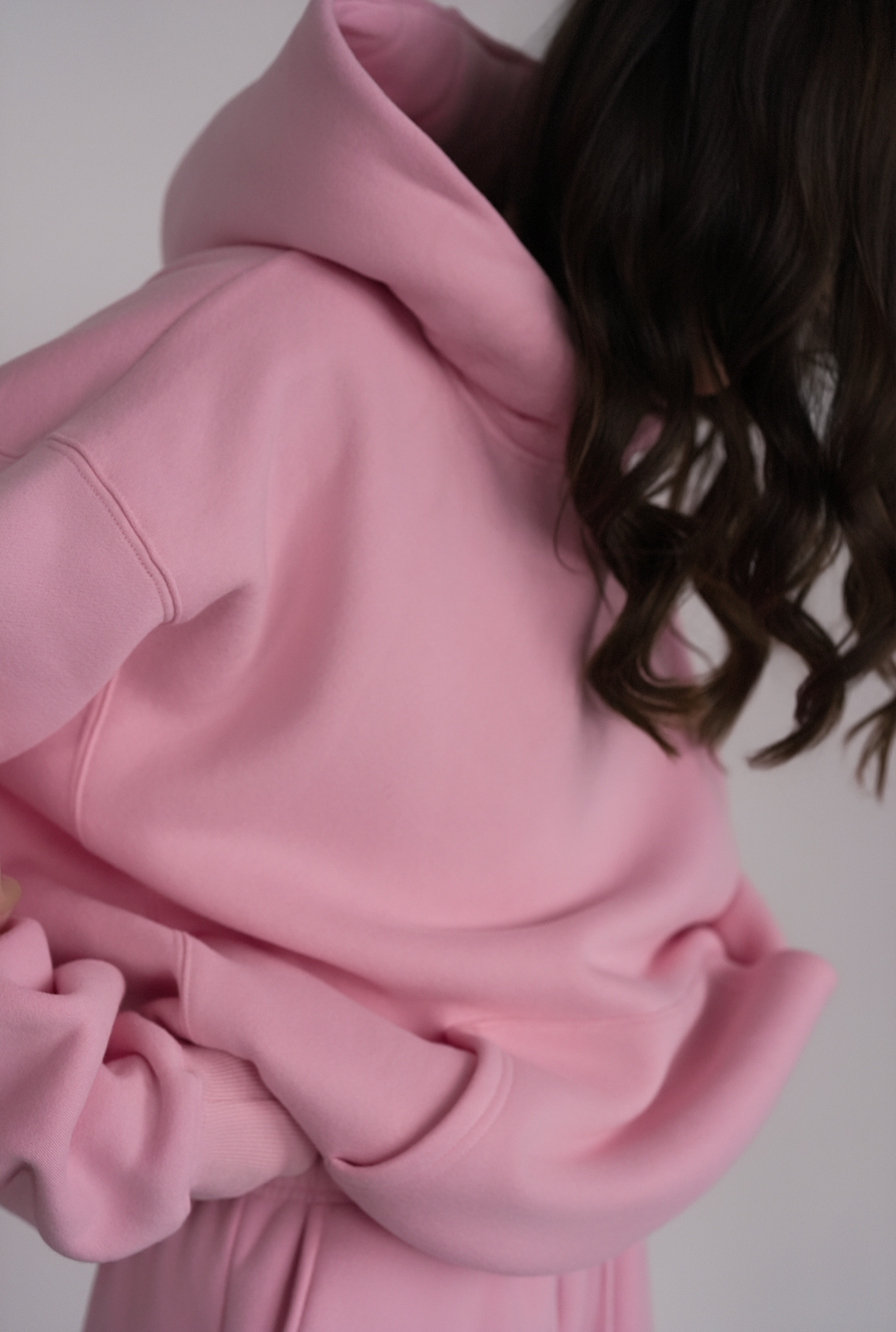 Close-up of a pink hoodie with a neutral background