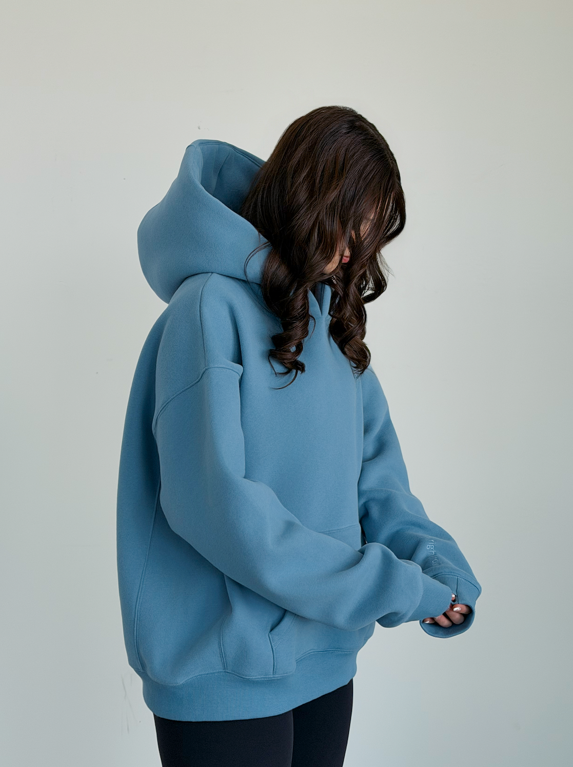 Person wearing a blue hoodie against a plain background