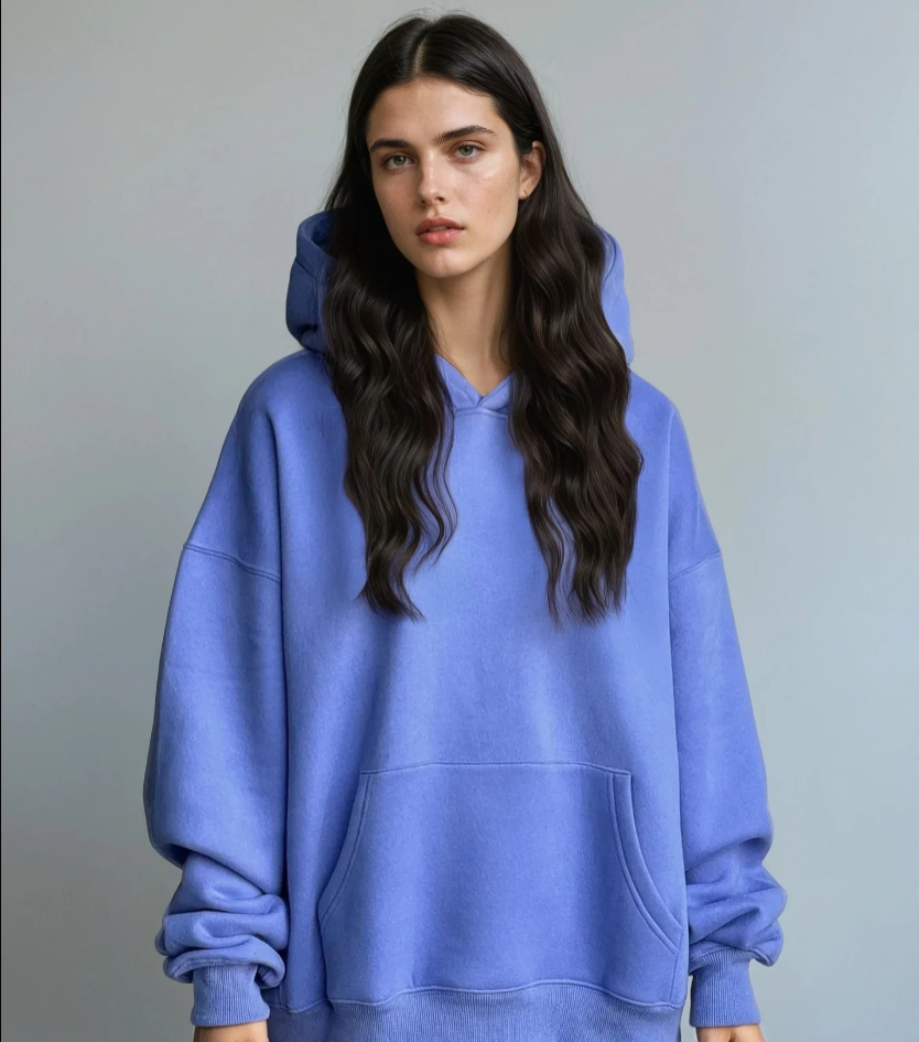 Person wearing a blue hoodie against a gray background