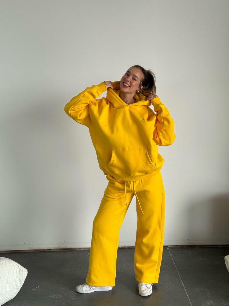 Person wearing a bright yellow tracksuit against a plain background