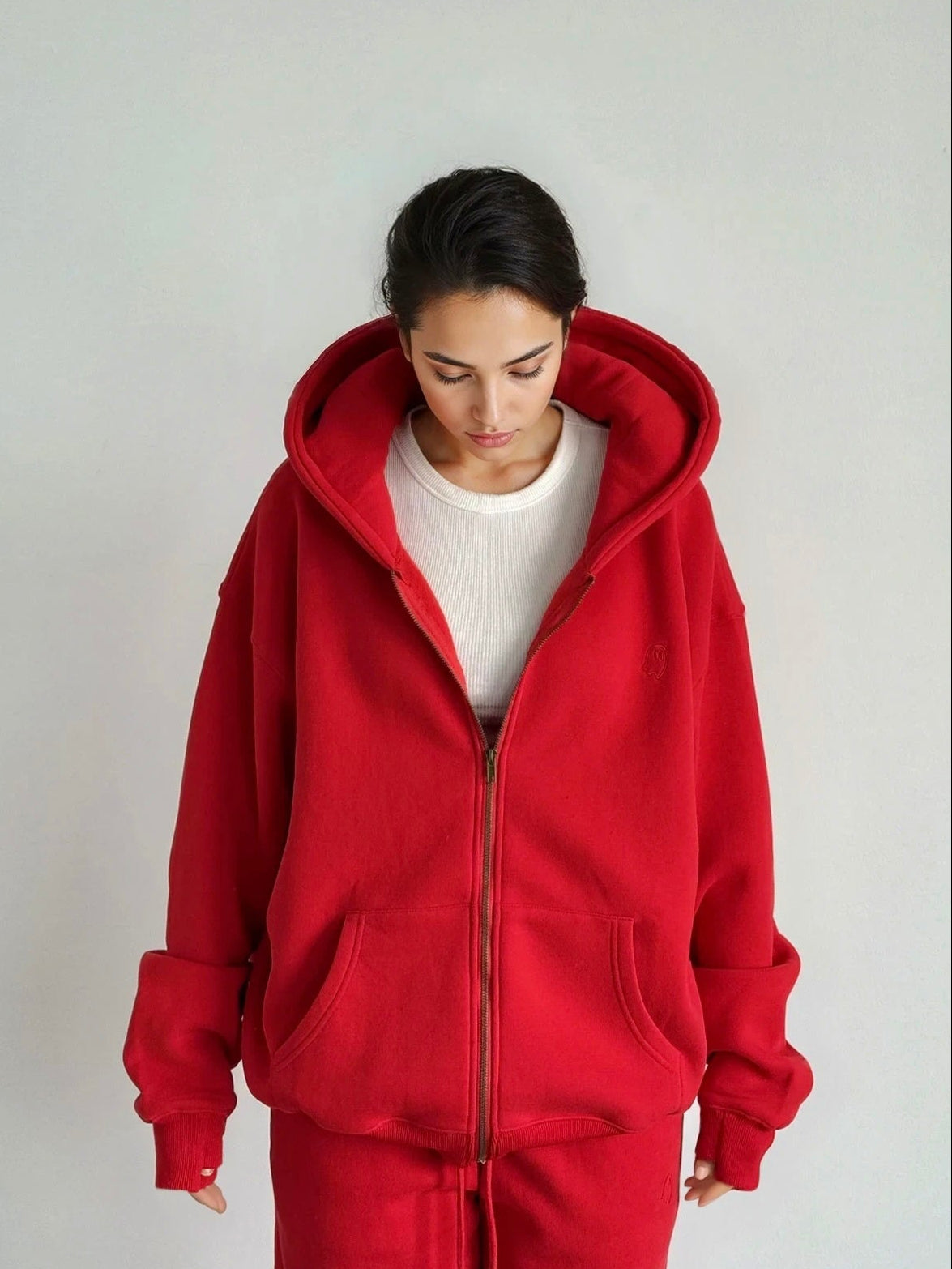 Person wearing a red tracksuit against a plain background