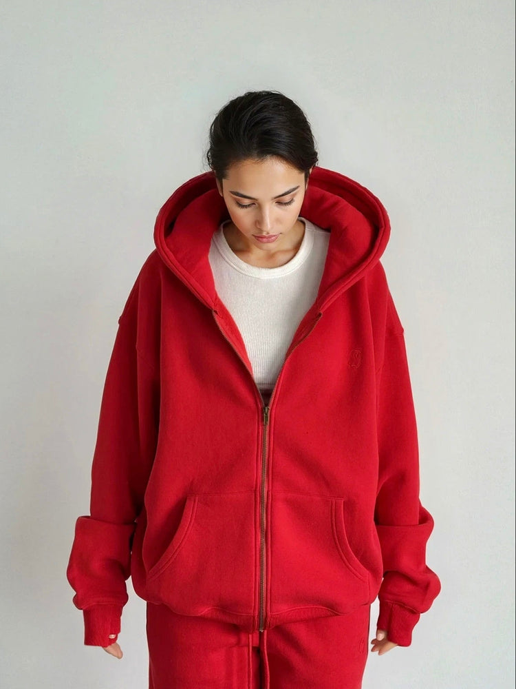 Person wearing a red tracksuit against a plain background